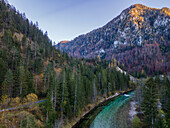 Aerial drone view of Salza River with a mountain peak in the background on a fall day under a clear sky surrounded by a forest, Wildalpen, Styria, Austria.