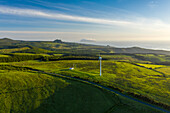 Aerial view of wind turbines in countryside at sunset on Ilha das Flores, Azores islands, Portugal.