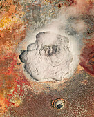 Luftaufnahme eines farbenfrohen Vulkankraters mit Dampf und rissigen Erdmustern, Hochland, Island.