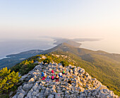 Luftaufnahme einer Gruppe, die auf dem Gipfel eines Berges Yoga praktiziert, Veli Lošinj, Kroatien.