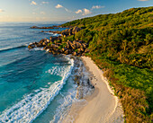 Aerial view of a person walking on the beach at Grand Anse, La Digue and Inner Islands, Seychelles.