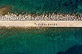 Luftaufnahme einer Gruppe, die an der künstlichen Seebrücke in Veli Lošinj, Kroatien, Yoga praktiziert.