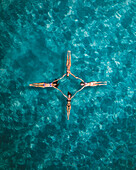 Aerial view of a sunny day gathering of joyful friends sunbathing on a tranquil and serene tropical island, Primorje-Gorski Kotar, Croatia.