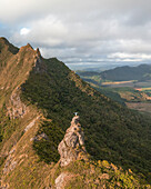 Aerial view of a person on top of Le Chat y La Souris mountain or Mount Villars, in the Bambous Range near Grand Sable, Flacq, Mauritius.