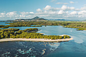 Aerial view of Ilot Mangenie island archipelagos along the coastline at sunset with mountain in background, Ilot Lievres, Flacq, Mauritius.