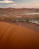 Luftaufnahme von Sossusvlei und Deadvlei mit Sanddünen und Personen, Hardap, Namibia.