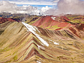 Aerial view of peaks of Vinicunca in clouds, Rainbow Mountain, Peru.