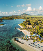 Aerial view of a beautiful beach along the coast with mountain in background in Ilot Lievres, Flacq, Mauritius.