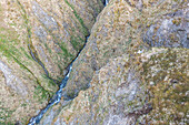 Aerial view of a small river streaming along the mountain on Unalaska island, Alaska, United States.