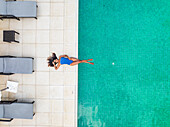 Aerial view of Anahita hotel with woman sunbathing on poolside, Flacq, Mauritius.