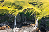 Aerial view of a waterfall along the coast, Makushin, Unalaska island, Alaska, United States.