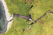 Aerial view of a waterfall along the coast in Broad Bay, Unalaska island, Alaska, United States.