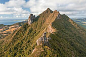 Aerial view of a person on top of Le Chat y La Souris mountain or Mount Villars, in the Bambous Range near Grand Sable, Flacq, Mauritius.