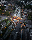 Aerial view of beautiful fenghuang ancient town illuminated at night with traditional architecture and a scenic river, Fenghuang Ancient Town, China.