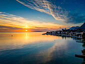 Luftaufnahme eines schönen Küstendorfs bei Sonnenuntergang mit heiteren Spiegelungen auf der Adria, Gradac, Kroatien