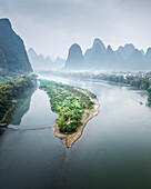 Aerial view of serene karst mountains and a tranquil river with lush greenery, Guilin, China.