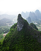 Aerial view of majestic karst mountains and lush valleys with misty atmosphere, Guilin, China.