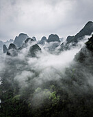 Aerial view of beautiful karst mountains shrouded in fog and clouds, Guilin, China.