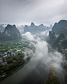 Aerial view of beautiful karst mountains and a scenic river shrouded in mist and clouds, Guilin, China.