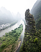 Aerial view of lush karst mountains and a serene river winding through a picturesque valley, Guilin, China.