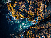 Luftaufnahme von zerklüfteten Klippen und krachenden Wellen im Meer, Cape Neddick, Vereinigte Staaten.