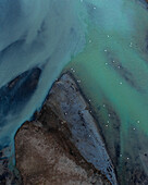 Aerial view of beautiful blue and green patterns, and swans swimming in the water of glacial river Héraosvotn in North Iceland.