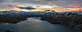 Panoramic aerial view of a mountain range with snow on the crests along the Dutch Harbour on Amaknak Island at sunset, Unalaska, Alaska, United States.