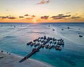 Aerial view of boats moored at the pier on the beach along the coastline at sunset in Noord, Aruba.