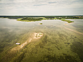 Aerial view of a family fishing on a small sand island in baltic sea in Estonia.