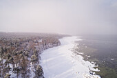 Aerial view of the snowy misty coast of Muraste in Estonia.