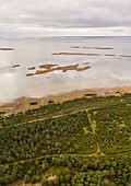 Aerial view of green coastline of Vormsi during cloudy weather in Estonia