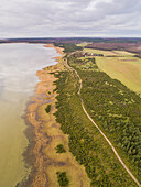 Aerial view of green coastline of Vormsi island during cloudy weather in Estonia