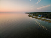 VORMSI ISLAND, ESTONIA – 2016-07-26 : Aerial view of two houses on the beach of Vormsi island at sunset in Estonia.