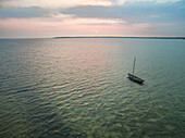 Aerial view of a small sailing boat moored in the sea at sunset in Estonia.