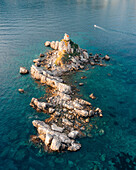 Luftaufnahme der Kirche St. Nedjelja auf einer felsigen Insel, umgeben von türkisfarbenem Wasser und der Adria, Petrovac, Montenegro.