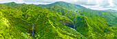 Luftaufnahme eines üppig grünen tropischen Tals mit majestätischen Bergen und einem ruhigen Wasserfall, Ost-Kauai, Vereinigte Staaten