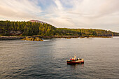 Aerial view of a fishing boat anchored at Sitka Point, Mt Edgecumbe, a dormant volcano rises above Kruzof Island, Tongass National Forest, Sitka, Alaska