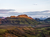 Aerial view of a beautiful mountain landscape with Torfajokull mountain in background at sunset in the highlands near Hella, Southern Region, Iceland.