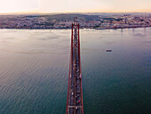 Panoramablick aus der Vogelperspektive auf die Autobahn am 25. April, Brücke über den Tejo mit der Innenstadt von Lissabon im Hintergrund, Lissabon, Portugal.