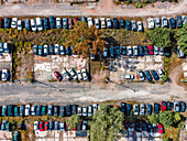 Aerial view of an abandoned junkyard with vehicles parked in a parking lot in Carnide, Lisbon, Portugal.