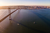 Panoramablick aus der Vogelperspektive auf die Autobahn am 25. April, Brücke über den Tejo mit der Innenstadt von Lissabon im Hintergrund, Lissabon, Portugal.