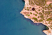 Luftaufnahme von oben auf die wilde Küste in der Nähe von Praia da Marinha mit kleinen paradiesischen Stränden bei Sonnenaufgang, Lagoa, Algarve-Region, Portugal
