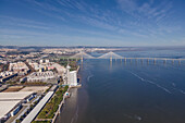 Luftaufnahme des Stadtteils Oriente von oben, Blick auf die Vasco-da-Gama-Brücke über den Fluss Tejo in Lissabon, Portugal
