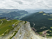 Luftaufnahme des Seceda-Kamms, eines beliebten Gipfels in den Dolomiten in der Geisler-Gruppe im Naturpark Puez-Geisler in Südtirol mit dem Dorf St. Ulrich in der Ferne, Norditalien.