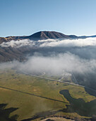 Luftaufnahme des Laceno-Sees (Lago Laceno), eines Stausees auf einem hoch gelegenen Berg mit niedrigen Wolken und Nebel in Bagnoli Irpino, Avellino, Irpinia, Kampanien, Italien