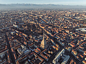 Aerial view of the Mole Antonelliana tower, a landmark building in Turin downtown at sunset with the Alps mountains range in background, Turin, Piedmont, Italy.