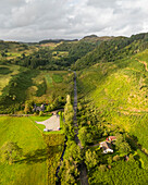 Luftaufnahme einer kurvenreichen Straße durch ein üppig grünes Tal, umgeben von ruhigen Hügeln und Bäumen, Lochgilphead, Vereinigtes Königreich