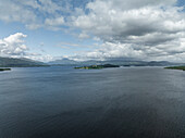 Aerial view of serene Loch Lomond surrounded by majestic mountains and clouds, Trossachs National Park, Scotland, United Kingdom.
