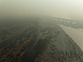 Aerial view of the serene Yamuna River with a bridge and lush greenery, Sadar Bazar, New Delhi, India.