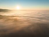 Aerial view of balze valdarno shrouded in fog and mist at sunrise, Tuscany, Reggello, Italy.